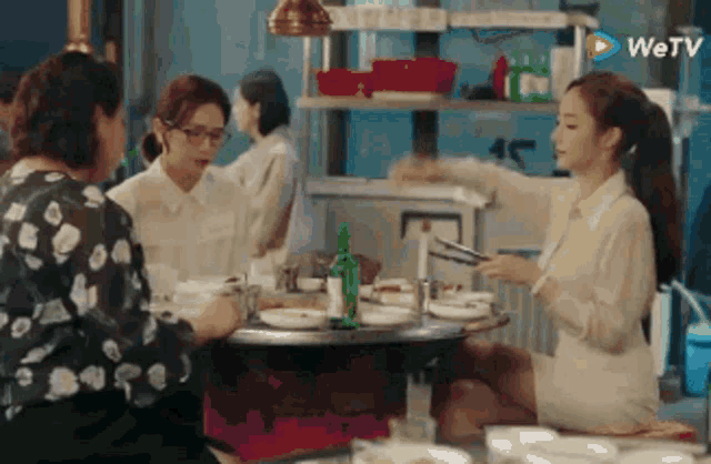 three women are sitting at a table in a restaurant .