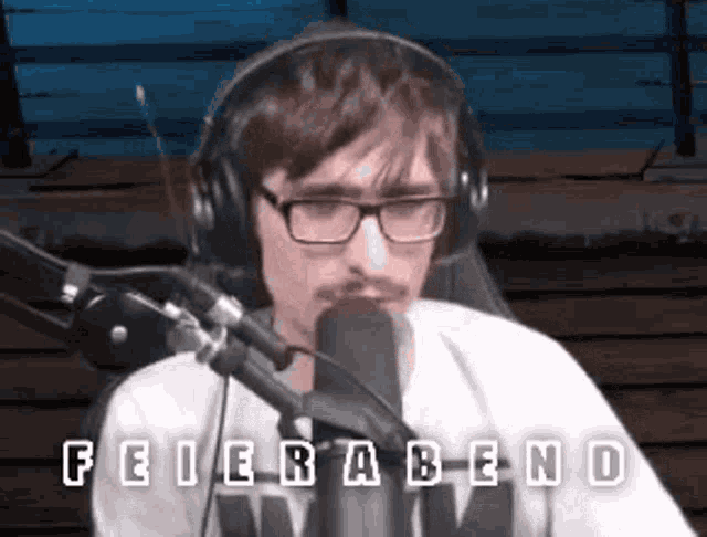 a man wearing glasses and headphones is talking into a microphone .