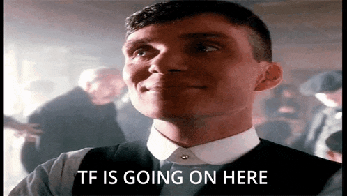 a man in a suit and tie is smiling and says `` tf is going on here '' in a crowded room .