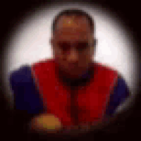 a blurry picture of a man in a red vest and sunglasses .