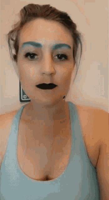 a woman with blue eyebrows and black lipstick