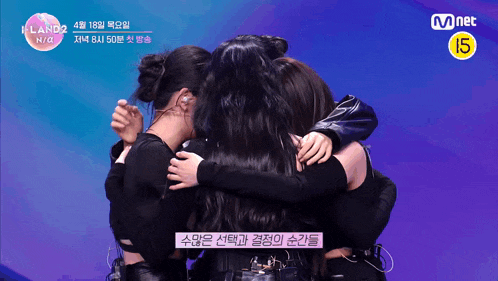 a group of girls are hugging each other with a mnet logo in the background