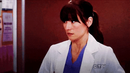 a woman in a lab coat is standing in a hallway with a sign that says ctv