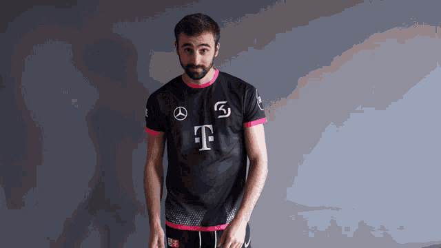 a man with a beard is wearing a black and pink t-mobile jersey