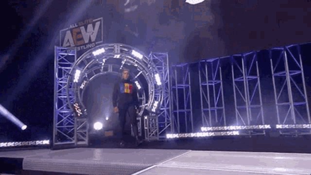 a wrestler is walking through a tunnel that says aew on it