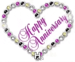 a heart shaped necklace with the words `` happy anniversary '' surrounded by rhinestones .