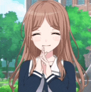 a girl with long brown hair is smiling with her hands folded in front of her face