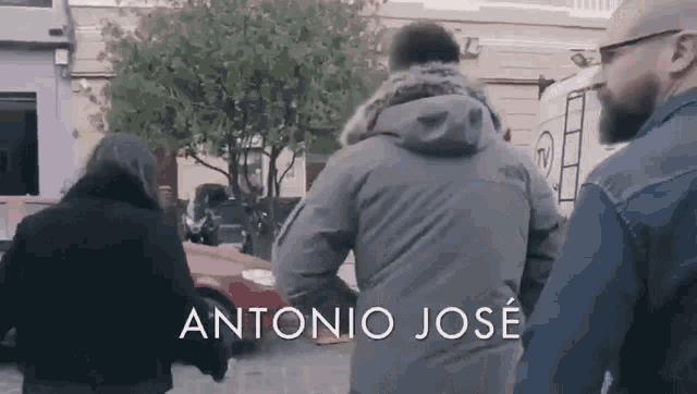 a group of people are walking down a street with the name antonio jose on the bottom
