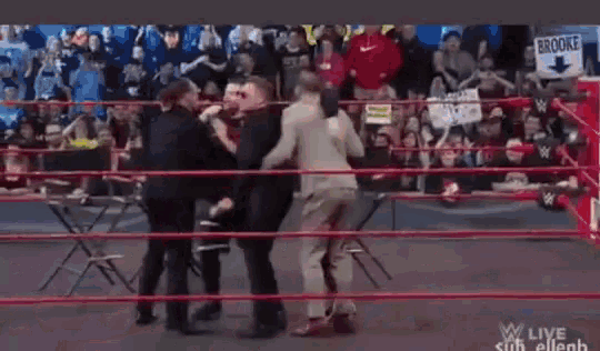 a group of wrestlers are fighting in a wrestling ring .