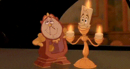 a clock and a lamp from beauty and the beast are standing next to each other and holding candles .