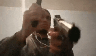 a man is holding a gun and wearing headphones .