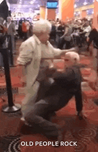 an elderly couple is dancing together in a casino .