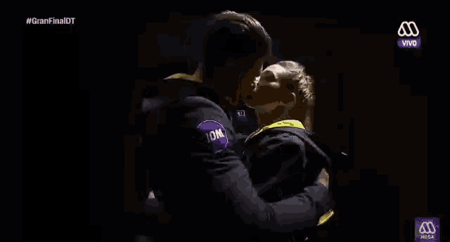 a man and a woman are kissing in front of a screen that says vivo on it