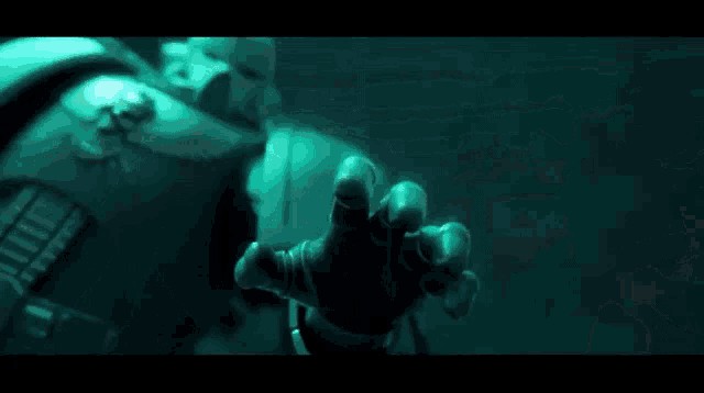 a close up of a person wearing a helmet with a green light coming out of it in a dark room .