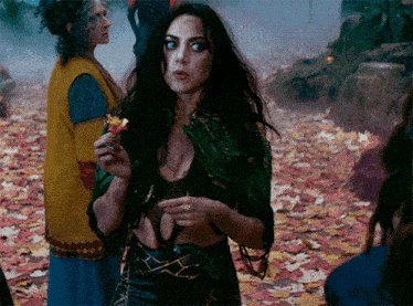 a woman with long black hair is holding a piece of fruit