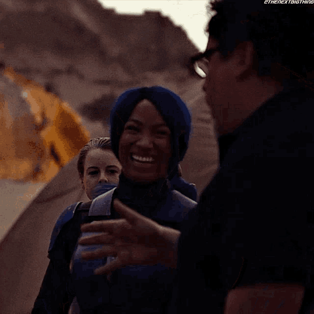 a man giving a thumbs up to a woman in a blue suit