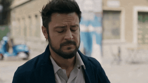 a man with a beard wearing a blue jacket