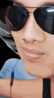 a close up of a person wearing sunglasses with a black background