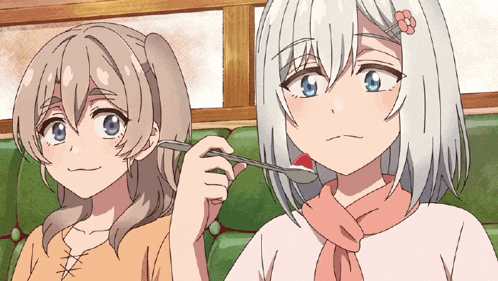 a girl with a flower in her hair is holding a spoon next to another girl