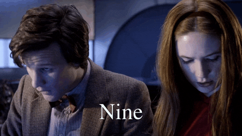 a man and a woman are standing next to each other and the word nine is on the bottom right