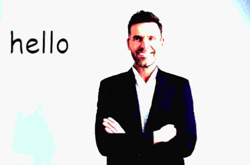 a man in a suit stands with his arms crossed in front of a white board that says hello