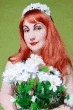 a woman with red hair holds a bouquet of white daisies