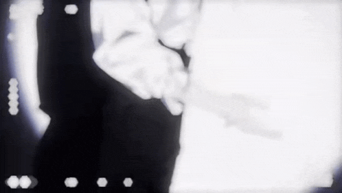 a blurry black and white photo of a man holding a gun .