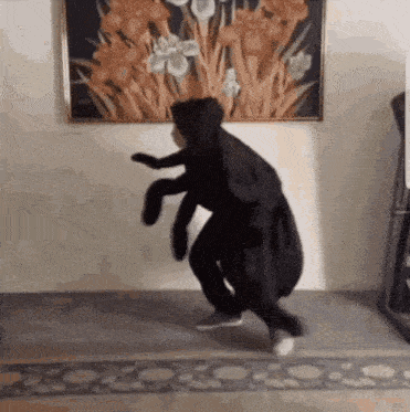 a person dressed as a bug is dancing in front of a painting of flowers .