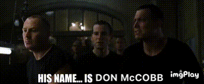 a man is standing in front of a group of people and his name is don mccobb .