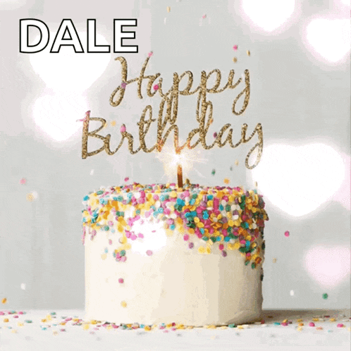 a birthday cake with sprinkles and a lit candle that says happy birthday