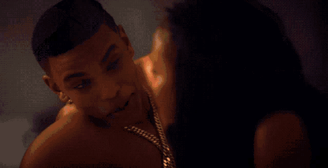 a shirtless man is being kissed by a woman