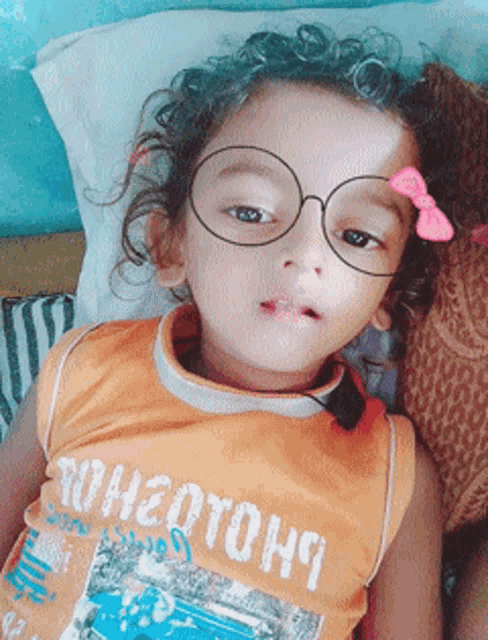 a little girl wearing glasses and an orange shirt that says rohatohs