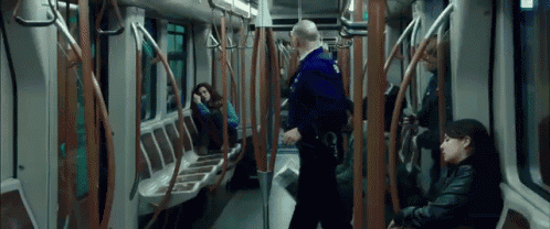 a man in a blue uniform is talking to a woman on a subway