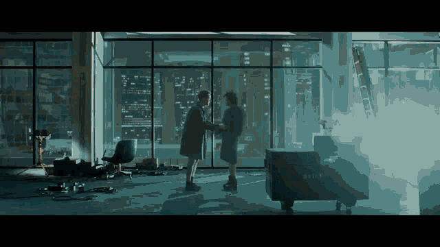 two people shaking hands in a dark room with a box that says billy on it