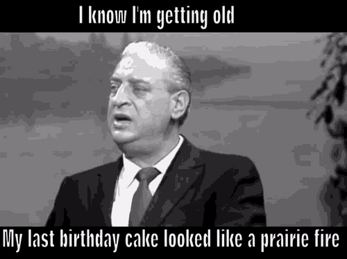 a man in a suit and tie is talking about his birthday cake