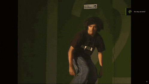 a skateboarder is doing a trick in front of a green screen that says " feeling " on it
