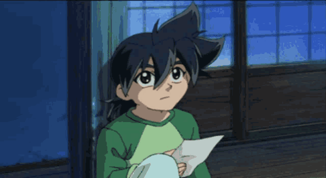 a boy in a green shirt is reading a letter