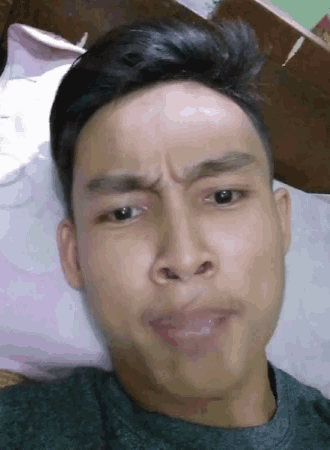 a man laying on a bed making a funny face with his mouth open
