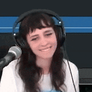 a woman wearing headphones and a microphone is smiling .