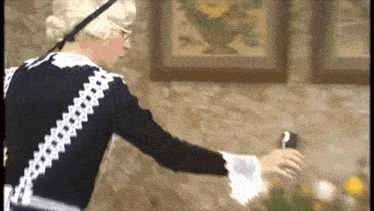 a woman in a black and white dress is holding a bottle of wine .