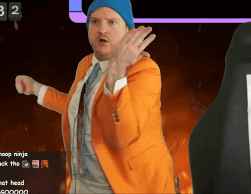 a man in an orange suit is dancing in front of a screen that says 32 on it