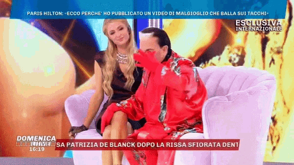 a man in a red robe is sitting on a couch with a woman in a black dress
