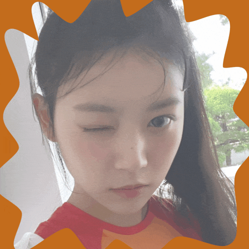 a close up of a woman 's face with an orange border