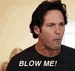 a man in a black shirt is making a funny face and says blow me .