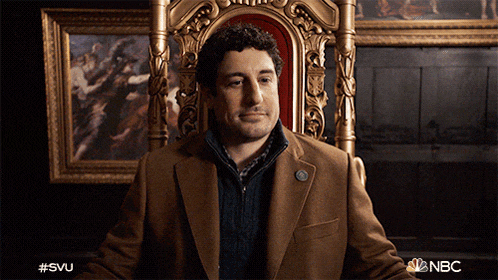 a man in a suit is sitting in a chair with the nbc logo on the bottom right