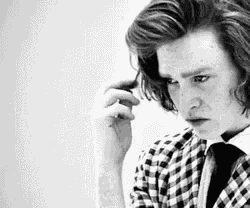 a man in a plaid shirt and tie is scratching his head .