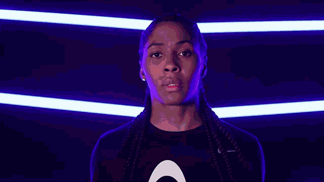 a woman is holding a basketball in front of a purple background .