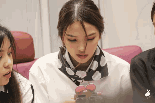 a woman with a scarf around her neck looks down
