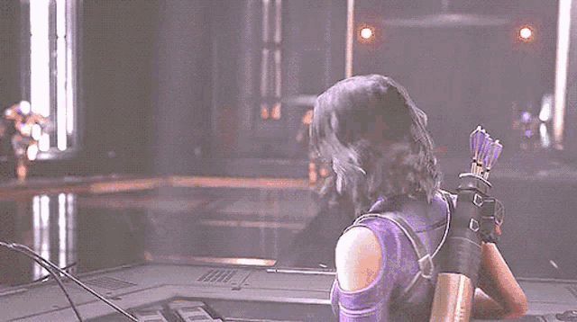 a person is standing in a dark room with purple lights coming out of them .