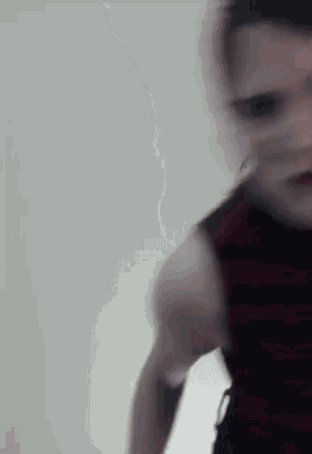 a blurry picture of a man in a black and red striped tank top .
